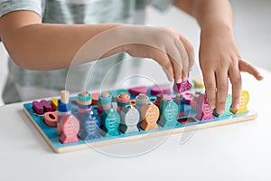 Eco-friendly developing toys. Close up shot of little kid playing with wooden fishing game, counting colorful figures