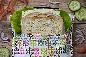 Eco-friendly durable reusable sandwich bag with healthy vegetables on a wooden cutting board