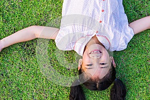 Eco friendly environment concept with happy healthy Asian kid having fun relaxing outdoor on natural green lawn living in beautifu