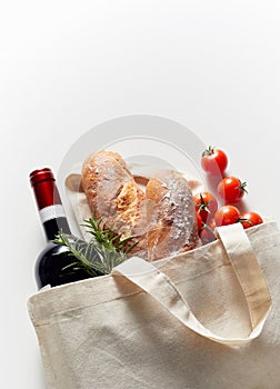 Eco-friendly fabric bag with groceries on white