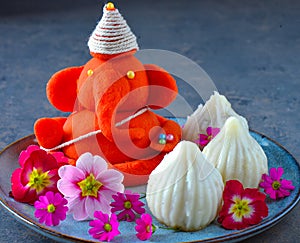 Eco friendly Idol of lord Ganesha with modak sweet and flowers