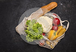 Eco friendly mesh bag with fruit and veggies on black background. No plastic. Zero waste and plastic free concept. Grocery