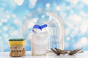 Eco-friendly natural cleaners baking soda, lemon and cloth on white and blue bubles background,
