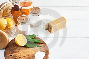 Eco-friendly natural cleaners: baking soda, soap, vinegar, salt, lemon and brush on table. Zero waste concept. Top view