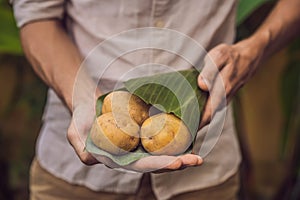 Eco-friendly product packaging concept. Potato wrapped in a banana leaf, as an alternative to a plastic bag. Zero waste