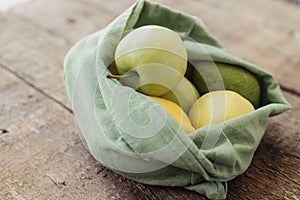 Eco friendly reusable bag for zero waste grocery shopping. Fresh apple, avocado, lemon in cotton bag