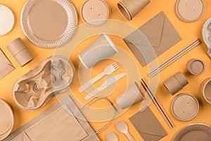 Eco-friendly tableware - kraft paper utensils on yellow or orange background. Street food paper packaging