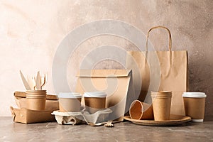 Eco - friendly tableware and paper bag on grey table