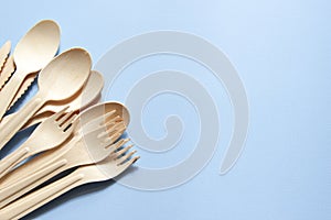 Eco-friendly tableware. Spoons, forks, knives made of wood. Tableware is on the left side