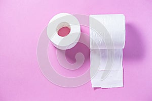 Eco-friendly white toilet paper on a pink background close-up