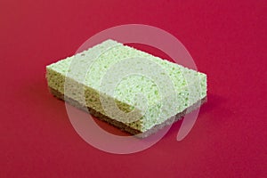 Eco green and brown sponge For Washing Dishes Isolated on red Background