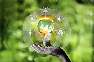 eco green energy consist ,wind, solar, water, biomass, geothermal and natural gas system.Hand holding bulb with world icon. It is