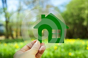 Eco house concept ,hand holding green eco house icon in nature