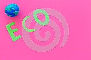 Eco icon cutout near planet Earth plastiline symbol on pink background top view copy space