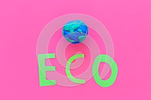 Eco icon cutout near planet Earth plastiline symbol on pink background top view copy space