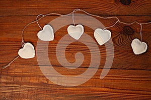 Eco linen fabric hearts on wooden background,Valentines Day concept design.Decorative white heart on jute twine garland