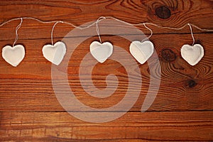 Eco linen fabric hearts on wooden background,Valentines Day concept design.Decorative white heart on jute twine garland