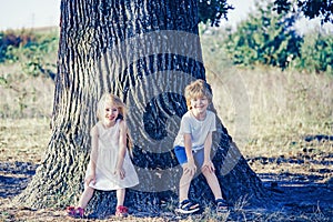 Eco living. Happy children farmers having fun on spring field. Children farmer in the farm with countryside background