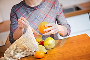 Eco packs. Woman hand getting out fruits after shopping from Eco bag. Anti-plastic bags. Zero Waste