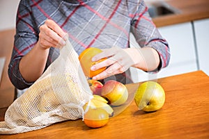 Eco packs. Woman hand getting out fruits after shopping from Eco bag. Anti-plastic bags. Zero Waste