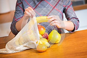 Eco packs. Woman hand getting out fruits after shopping from Eco bag. Anti-plastic bags. Zero Waste