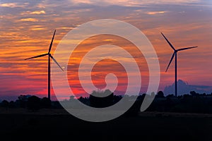 Eco power in wind turbine farm with sunset