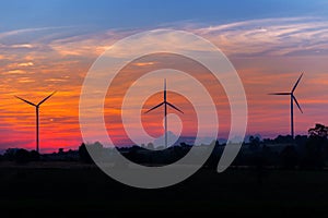 Eco power in wind turbine farm with sunset