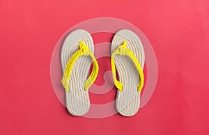 Eco yellow bamboo flip flops on red background Flat lay, top view.