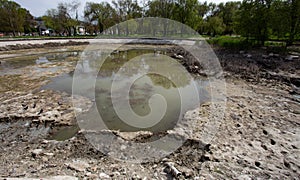 Ecological catastrophy. Drying lake in city park. Dry swamp lake disappears, idea and concept of environmental conservation,