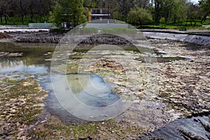 Ecological catastrophy. Drying lake in city park. Dry swamp lake disappears, idea and concept of environmental conservation,