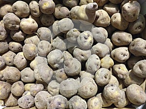 Aerial view of organic potatoes in bulk. Raw Sweet potato pile display at fresh market stall. Background of fresh and raw potatoes