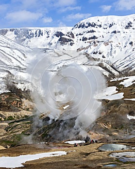 Ecological trail with tourists on the background of vapors and gases of the Valley of Geysers