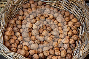 Ecological walnuts in a wicker basket for sale at farmer\'s market, autumn harvest, healthy food