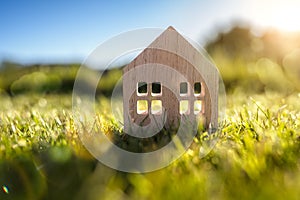 Ecological wood  model house in empty field at sunset