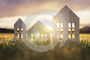 Ecological wood  model house in empty field at sunset