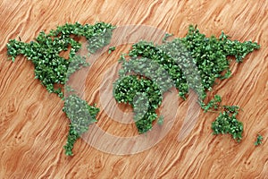 Ecological world map consisting of green grass and tropical leaves on wooden background. Concept of recycling garbage, air