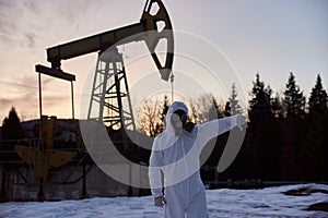 Ecologist giving thumbs down at oil field.