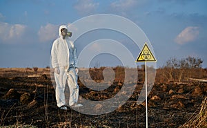 Ecologist standing in field with burnt grass.