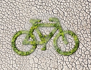 Ecology bike from grass on cracked earth background
