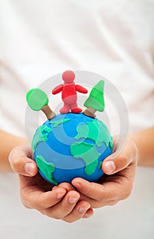 Ecology concept with clay world globe in child hand