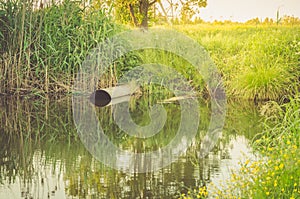 Ecology concept: water gushing from the sewer to river/sewer pipe pour out to the river