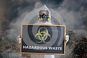 Ecology and pollution concept. Man in coveralls is warning against hazardous waste