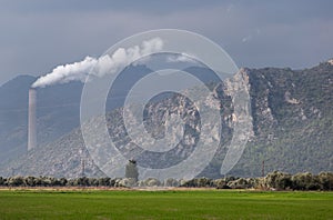 Ecology pollution. White steam comes from the pipe. Industry factory on the field. Landscape background.