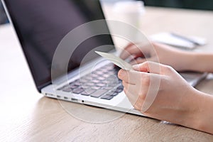 Ecommerce concept, Woman using credit card with ecommerce website via laptop on wooden desk