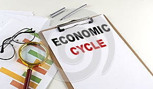 ECONOMIC CYCLE text on clipboard on white background, business concept