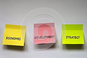 `Economic development strategy`, the phrase is written on multi-colored stickers on white background.