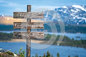 economic environmental social text on wooden signpost