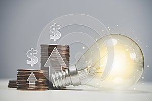 Economic and investment growth in the United States of America. Light bulb as idea with stacks of coins and up arrows.