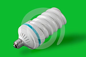 Economic light bulb standing on green background