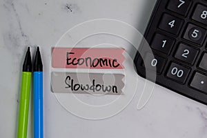 Economic Slowdown text on sticky notes with color office desk concept photo